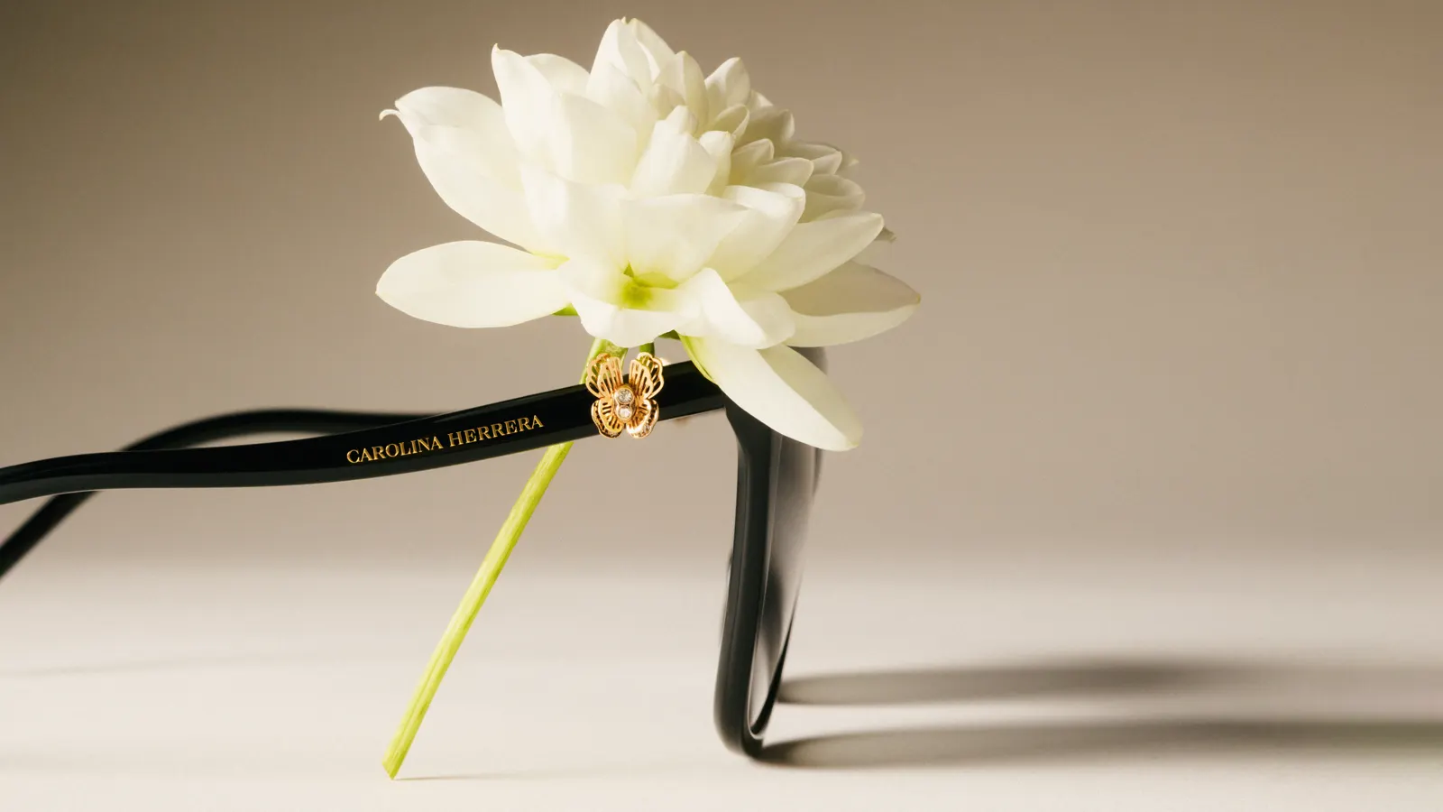 Detalle de gafas de sol cat-eye Carolina Herrera con flor blanca