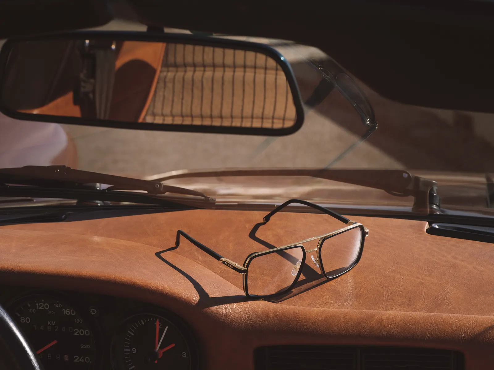 Gafas Carrera 1146 aviador negras sobre salpicadero vintage