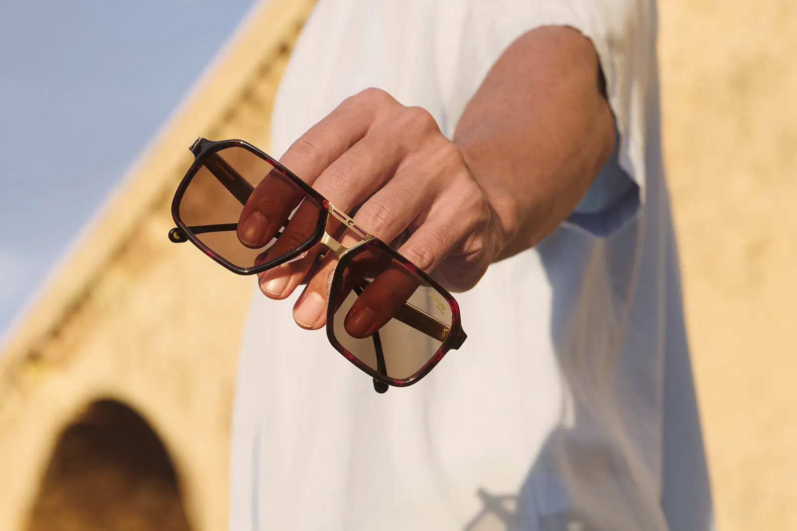 Gafas Carrera pilot carey en mano sobre puente